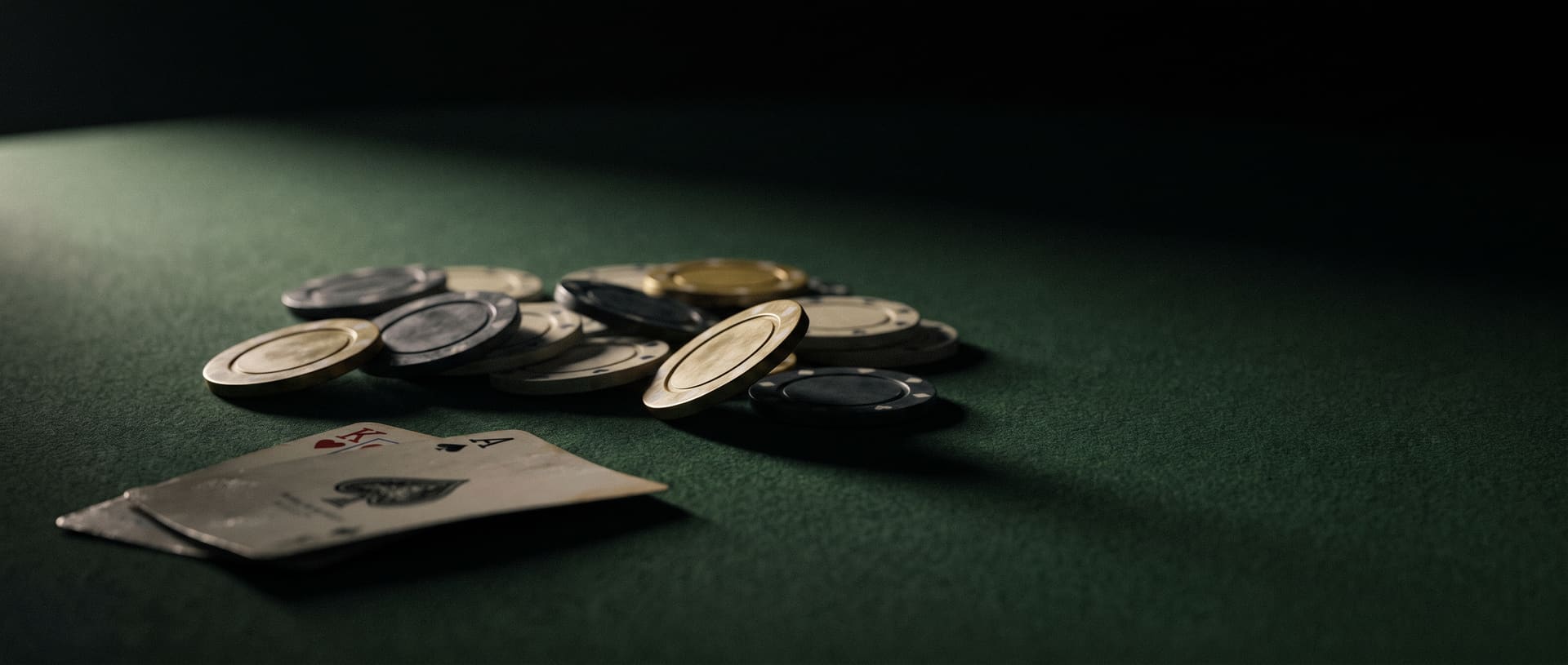 Two hole cards and a pot of clay chips on dark green felt, lit from one side.